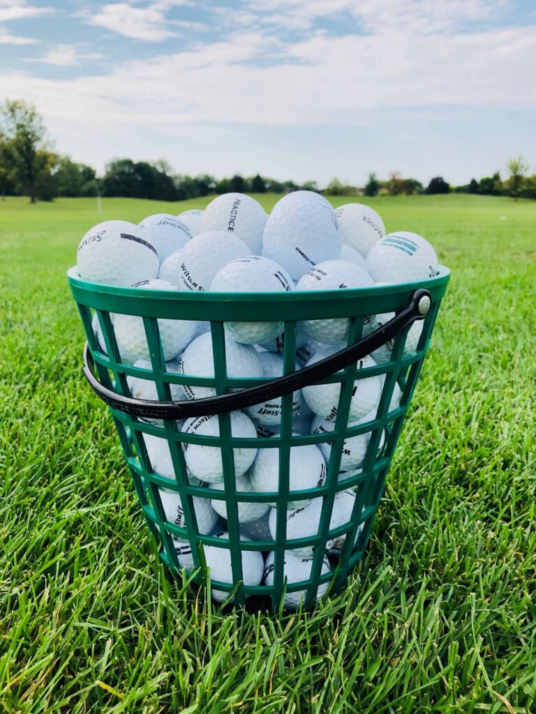 a green golf ball basket filled with golf balls